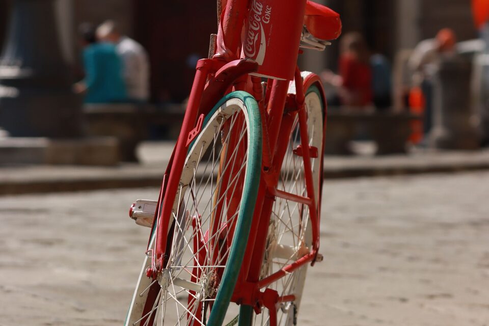 Een rode fiets geparkeerd in een straat, illustratieve foto.