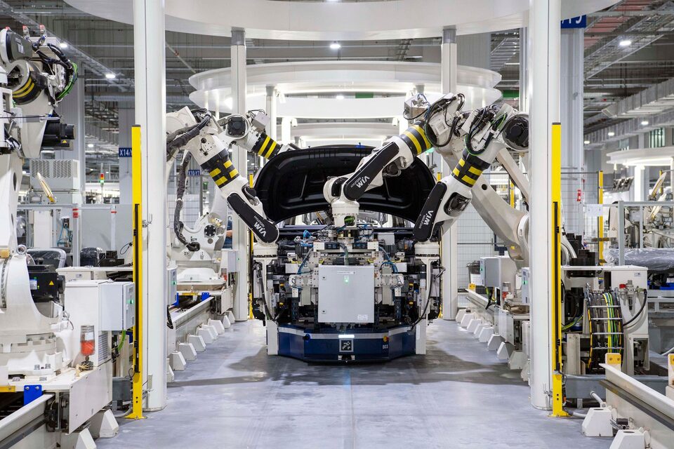 Des robots assemblent une carrosserie dans une usine automobile contemporaine, photo d’illustration.