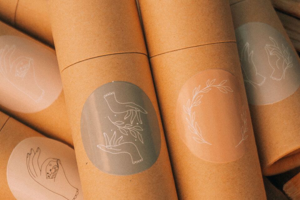 Brown cardboard cylindrical packages carry illustrated labels.
