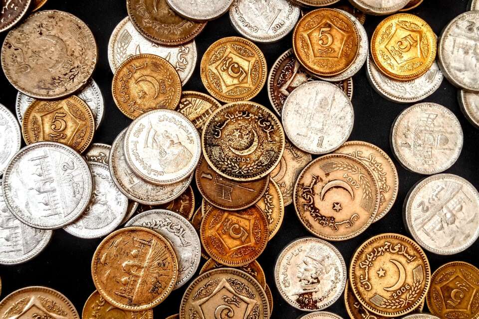 An assortment of coins on a dark background, illustrative photo.